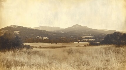 Fototapeta premium Vintage sepia-toned landscape of rolling hills and fields with a grainy texture.