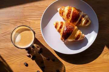 breakfast with coffee and croissant on wooden background