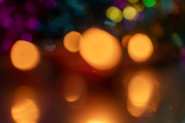 Abstract blurred warm bokeh lights against a dark background.