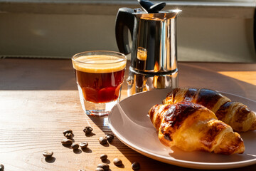 breakfast with coffee and croissant on wooden background