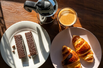 breakfast with coffee and croissant on wooden background