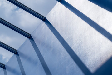 Sunlight streams through narrow, slanted beams, casting long shadows onto a smooth, reflective...