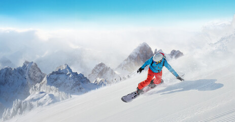 Snowboarder running downhill on sunny alpine slope