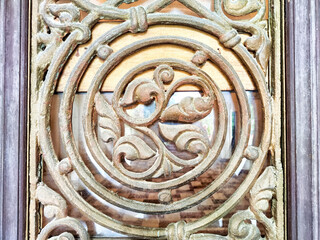 Intricate decorative ironwork displaying floral patterns in a historic building's window