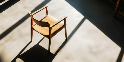 Modern wooden chair casting long shadows from window light