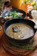 Zalewajka, a traditional country Polish soup, with potatoes, homemade sourdough, bay boletes and thyme, vertical view.