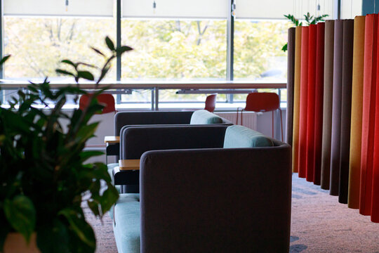 Bright and inviting workspace featuring comfortable chairs, vibrant fabric panels, and abundant natural light.