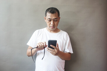 Fototapeta premium Man Using Smartphone, Concentrated Expression, Casual Attire