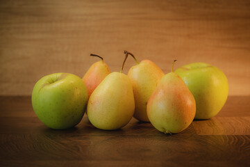 Whole pears and apples on a wooden background. Close up.