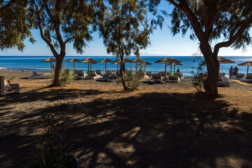Ombrelloni di paglia sulla spiaggia di Kamari beach a Santorini Grecia