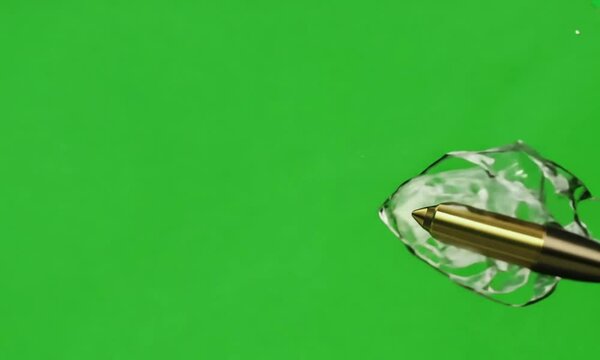 A bullet flying in slow motion, creating air ripples as it moves, on a green screen background.
