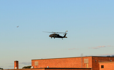 A Helicopter Hovers Over a Building at Sunset, Highlighting Its Impressive Maneuverability and...