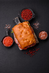 Focaccia with salami, cheese, tomatoes, arugula, salt, spices and herbs