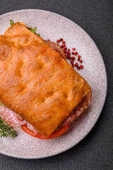 Focaccia with salami, cheese, tomatoes, arugula, salt, spices and herbs