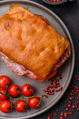 Focaccia with salami, cheese, tomatoes, arugula, salt, spices and herbs