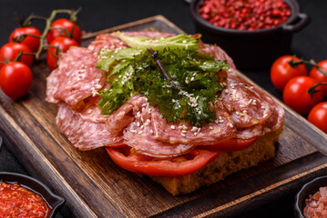 Focaccia with salami, cheese, tomatoes, arugula, salt, spices and herbs