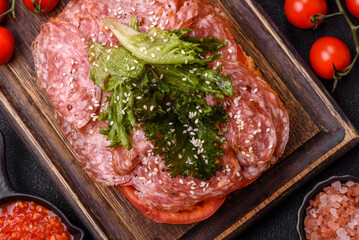 Focaccia with salami, cheese, tomatoes, arugula, salt, spices and herbs