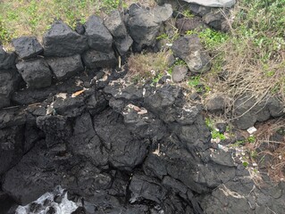 A collection of rocks clustered together on a grassy field surface