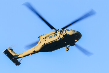 Fototapeta premium Military Helicopter Flying in Clear Blue Sky During Daytime, Showcasing Tactical Design and Maneuverability