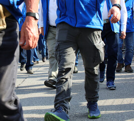 legs of striking workers marching on the street during a peaceful protest to increase factory...