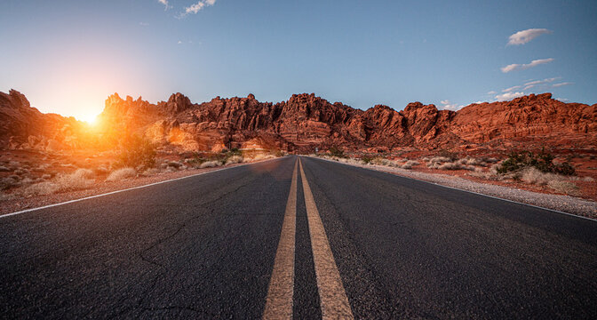 Empty long nevada mountain road to the horizon on a sunny summer day at bright sunset