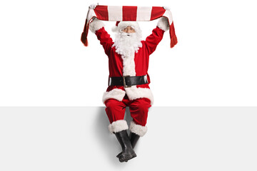 Santa claus cheering with a scarf and sitting on a blank panel