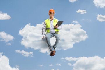 Full length portrait of a mature male engineer sitting on a cloud