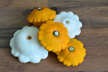 a group of pumpkins with a white squash on a wooden surface  