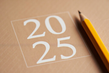 2025 brown diary with pencil on top of wood table