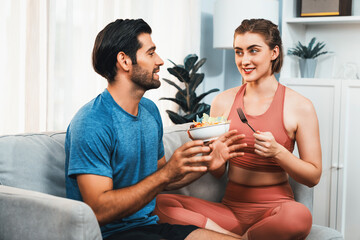Healthy sporty and vegetarian couple in sportswear with a bowl of fruit and vegetable. Healthy cuisine nutrition and vegan lifestyle for fitness body physique at gaiety home concept.