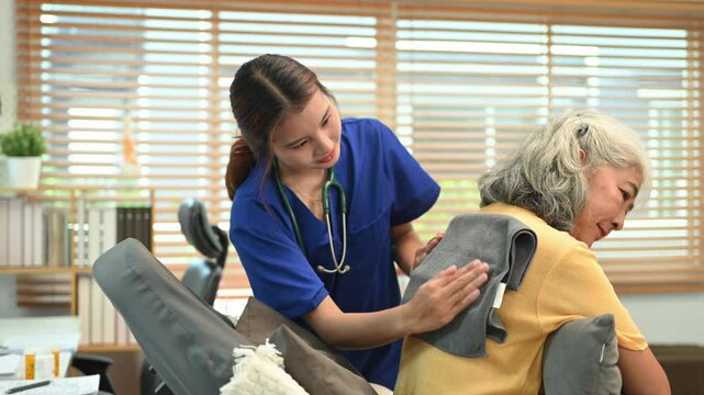 Physical therapist doing back percussion on a senior patient to help loosen and drain secretions from her lungs