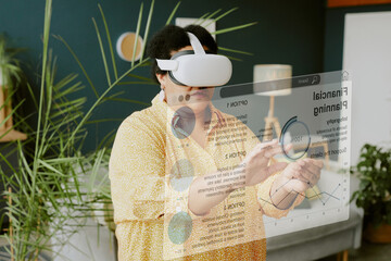 High angle shot of African American mature woman wearing VR headset and gesticulating in air
