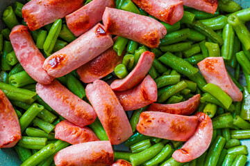 closeup full-frame high angle view background of roasting sausages with green beans