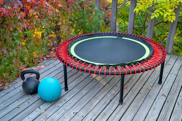 mini trampoline for fitness exercising and rebounding, slam ball and iron kettlebell in a backyard