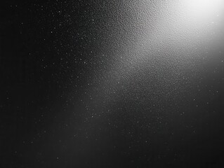 black and white grainy gradient background with an illuminated spot on dark gray noise texture, creating a dramatic and artistic backdrop perfect for graphic design applications