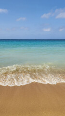 Beautiful view on blue sky and azure coast sea with soft blue ocean wave. Vertical photo. Natural blurred defocused background
