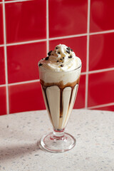 Glass of appetizing sweet milkshake cocktail with syrup