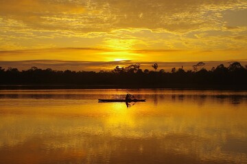夜明けのアマゾン河を行く一艘の舟