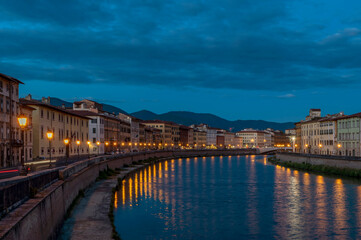 White light holders of various shapes are attached to the windows of buildings along the banks of the Arno River in Pisa, Italy, ahead of the feast of San Ranieri