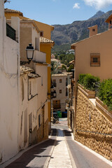 Narrow street descending between Mediterranean houses and mountains