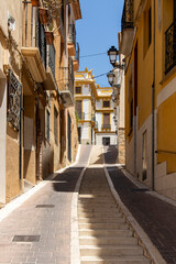 Naklejka premium Narrow cobblestone street with ascending stairs