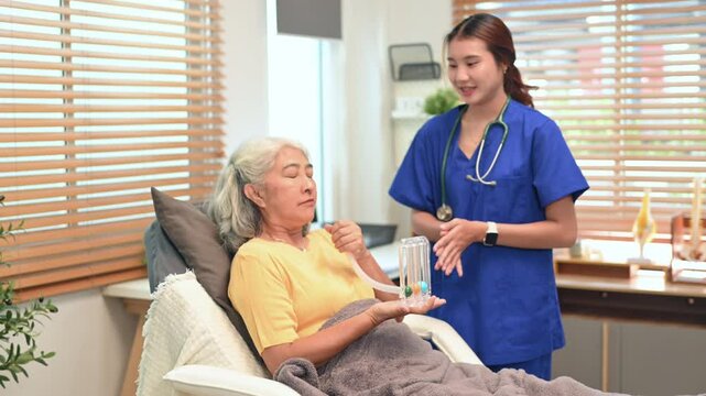 Physical therapist assisting mature woman with using a spirometer to improve the functioning of lungs