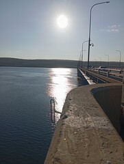 pier at sunset. Bridge over the river. Sun glare on the water