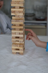 Board games  close-up of a hand building a tower of wooden blocks © Gosia