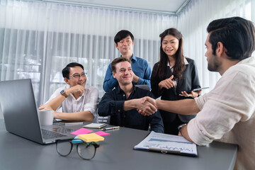 Diverse group of office employee worker shake hand after making agreement on strategic business marketing meeting. Teamwork and positive attitude create productive and supportive workplace. Prudent