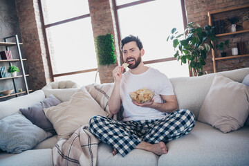 Photo of funny nice bearded man in pajamas enjoying weekend at home alone watching movie living...