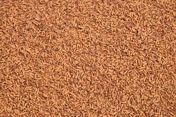 Abstract shapes, patterns and textures of the surface of sun-dried cloves.Harvesting cloves in the countryside. The red and brown colors of dried cloves. For graphic design or banner background