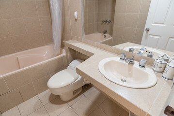 baño de departamento con acabados de loza , lavabo inodoro y ducha con tina