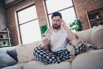 Photo of young sick ill man wearing pajama wrapped warm plid staying home feeling unwell migraine indoors
