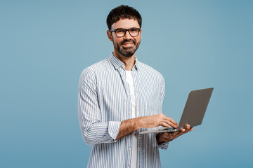 Successful businessman, freelancer wearing eyeglasses using laptop, copywriter typing on keyboard